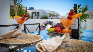 A table set with two martini glasses, a bottle of Rioja wine, and a fruit basket. - Cozy apartment with pool (CN)