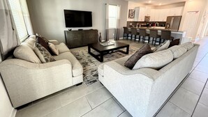 A modern living room with a sofa set, a coffee table, and a flat-screen TV. - Cinema Paradise: Last Minute Deal Private Pool/Spa (Davenport)