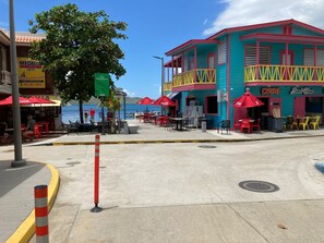 A waterfront dining area with outdoor seating, a beach house, and a bar. - Yagueri 16 - Your Ideal Family Retreat in Villa Taina de Boqueron, sleeps 8 (Cabo Rojo)