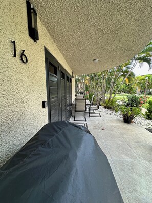 A covered outdoor seating area with a bench, a table with chairs, and a view of a garden with palm trees and plants. - Yagueri 16 - Your Ideal Family Retreat in Villa Taina de Boqueron, sleeps 8 (Cabo Rojo)