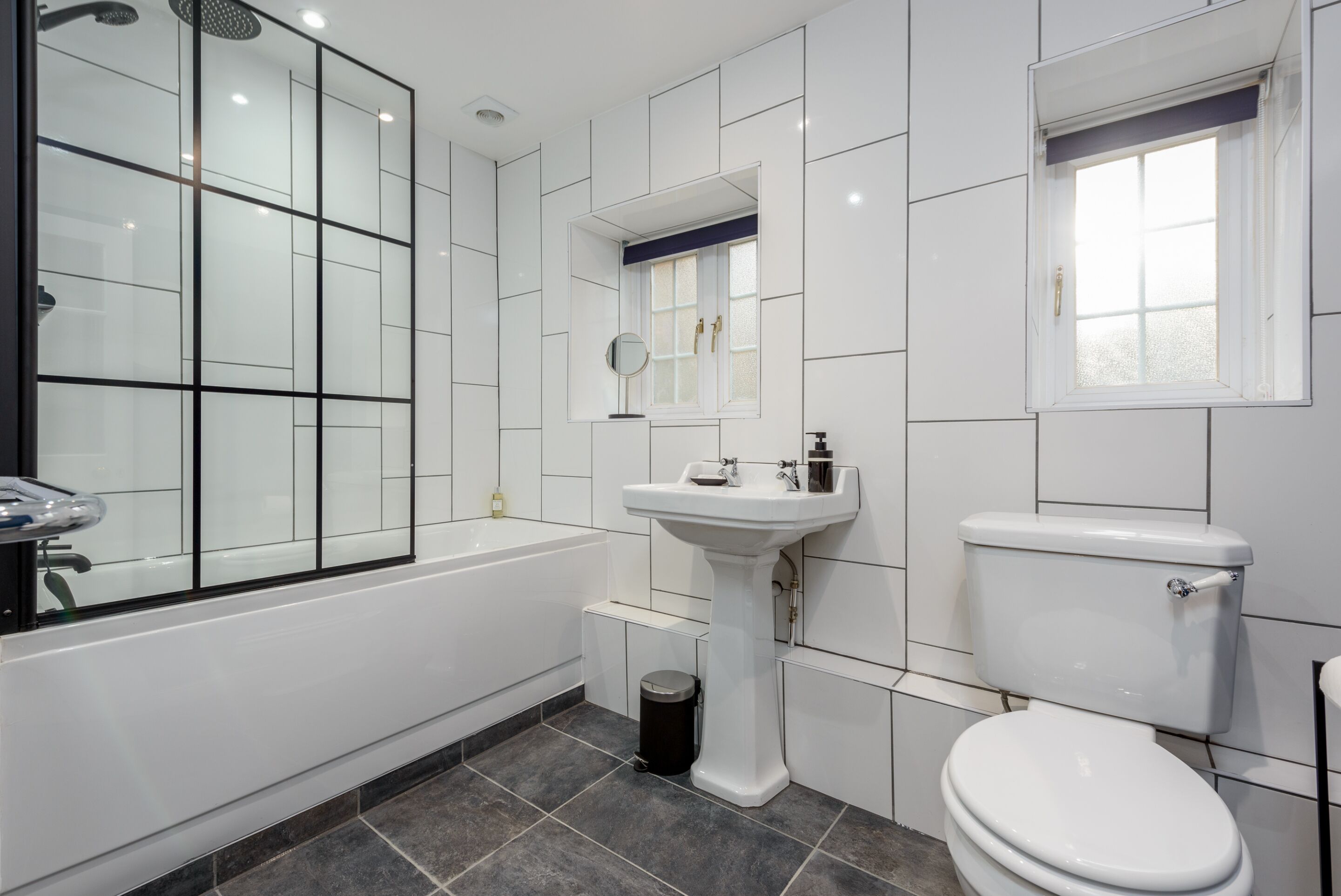 A modern bathroom with a bathtub, a sink, and a toilet.