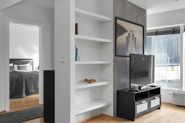 Une chambre moderne avec un lit, une télévision et des étagères intégrées.