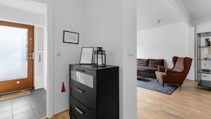Un salon moderne avec un meuble de rangement noir, un fauteuil en cuir marron et un plancher en bois.