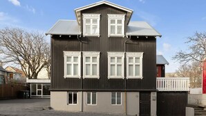 A two-story building with a dark exterior, multiple windows, and a small porch area. - Fantastic Studio in the city center B3 (Reykjavík)