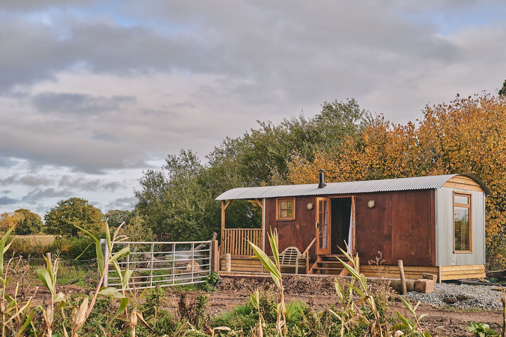 Une cabane rustique avec un toit en métal, une porte en bois et un petit porche.