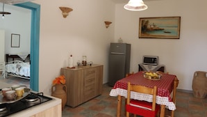 Una cucina funzionale con tavolo, frigorifero e forno a microonde.