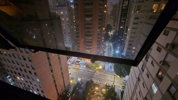 Un immeuble de grande hauteur, doté de nombreux étages et de nombreuses fenêtres, vu depuis un bâtiment plus bas.
