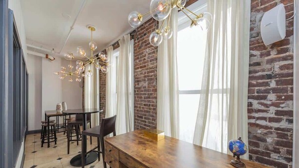 A dining area with a wooden table, chairs, and a globe on the table. - 2 Lofts on Broadway Strip - Sleeps 10 (Nashville)