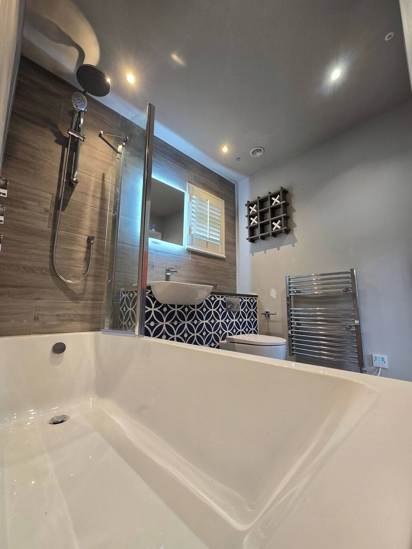 A modern bathroom with a freestanding bathtub, a glass-enclosed shower, and a vanity with a mirror.