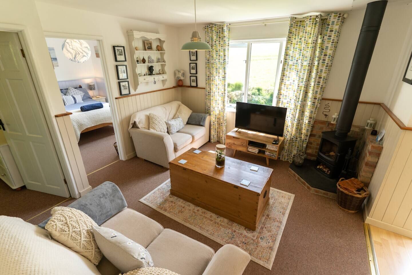 A cozy living room with a sofa, a coffee table, a TV, and a fireplace.