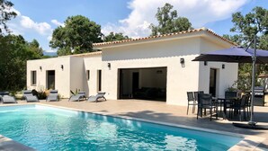 A modern poolside area with a pool, lounge chairs, and a patio with outdoor furniture. - Villa heated pool & garden •Town center 5 min •Beaches 10 min •Cleaning included (Porto Vecchio)