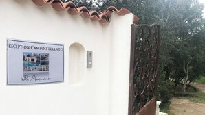 A reception sign for a property named 'Villa Avenenza' with a gated entrance and a dirt path leading to it. - Villa heated pool & garden •Town center 5 min •Beaches 10 min •Cleaning included (Porto Vecchio)