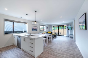Enjoy a spacious open-plan layout with a kitchen, dining area, and living space, featuring a dishwasher and large island with sink.