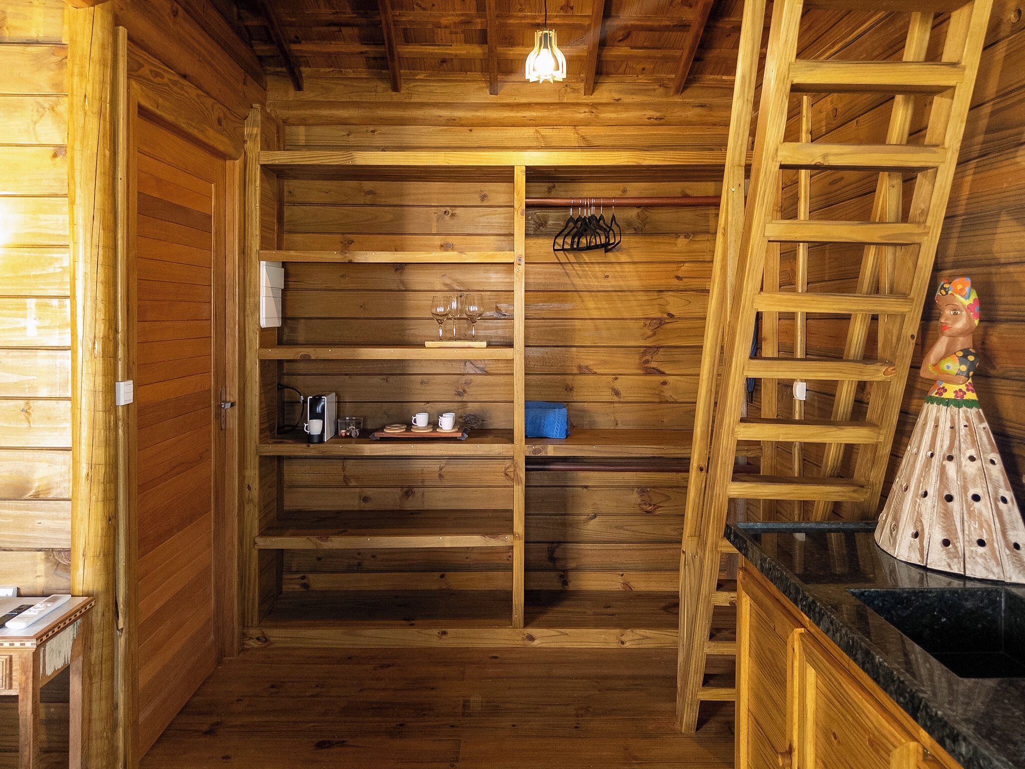Un intérieur en bois comprenant un coin cuisine, une machine à café et un étendoir.
