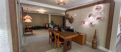 A spacious dining area with a wooden table and chairs, a brick wall, and decorative wall art.