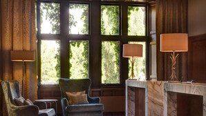 Ein Zimmer mit einem großen Fenster, einer Marmorplatte und zwei Sesseln.