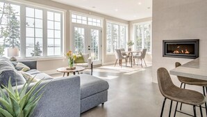 A spacious living room with a fireplace, a dining area, and large windows. - Stunning Ocean Front cottage, minutes from the beach (bayswater)