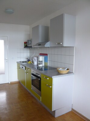 A kitchen with a stainless steel oven, a coffee maker, and a microwave on the countertop.