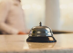 A close-up of a hotel room's reception area with a metallic bell and a blurred background. - Your Dynamic Retreat | Park Circle Paradise (North Charleston)