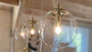 Een kamer met een in het plafond gemonteerd lamparmatuur met meerdere bolvormige glazen lampen.