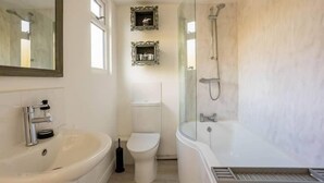 A modern bathroom with a freestanding bathtub, a toilet, and a sink.