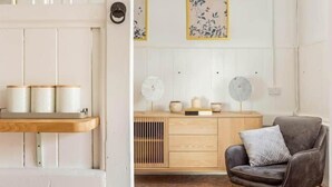 A room with a wooden cabinet, a gray armchair, and two wall-mounted fans. - Historic Stable on a Private Vineyard (Blandford Forum)