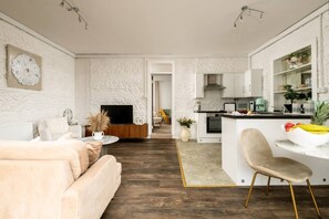 A modern living room with a sofa, a coffee table, and a TV.