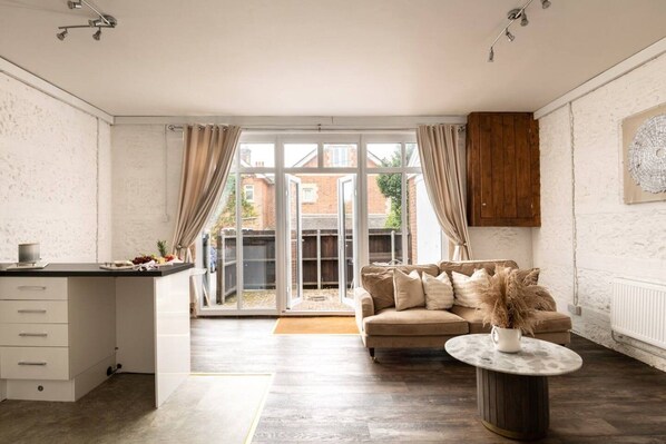 A modern kitchen with a dining area, a sofa, and a coffee table.