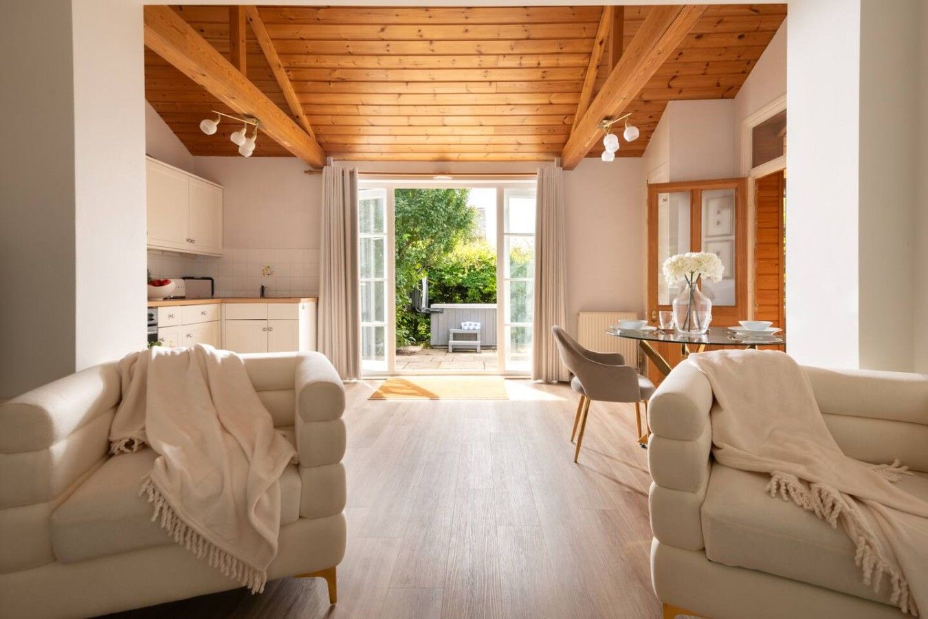 Un intérieur moderne comprenant deux canapés, une table à manger et un coin cuisine.