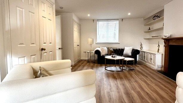 Un salon moderne avec un canapé blanc, une table basse et une cheminée.