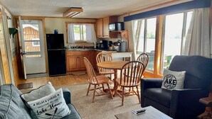 Un espacio habitable compacto con kitchenette, comedor y zona de estar.
