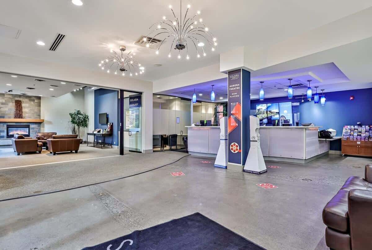 Un hall d’entrée moderne avec un comptoir d’accueil, un espace salon et une cheminée.
