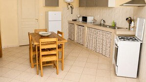 A compact kitchen with a dining table, cabinets, a stove, and a water heater. - 4-bedroom apartment near the beaches and attractions • Gated and secure residential community • The Beleric (Dakar)