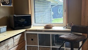 Keittiössä on puinen työtaso, mikroaaltouuni, pesuallas ja ikkuna, josta avautuu näkymä takapihalle.