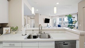 A modern kitchen with a double sink, white cabinets, and a dishwasher. - Sparks Marina 2BR · Waterfront Views & Jacuzzi (Sparks)