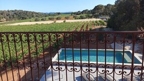 Une piscine offrant une vue sur les vignes et un paysage vallonné.