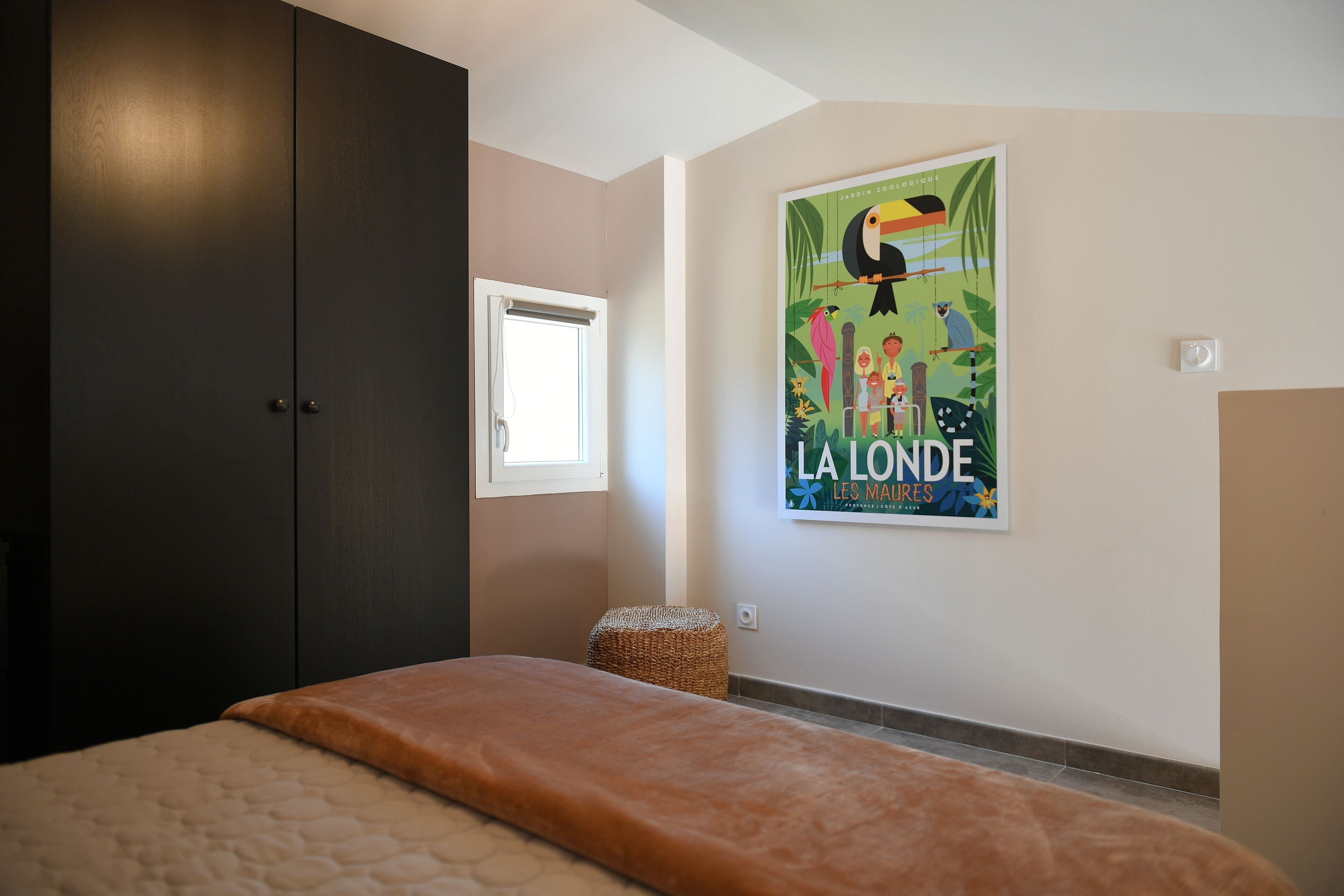 Un dormitorio con cama, armario, ventana y un cartel en la pared.
