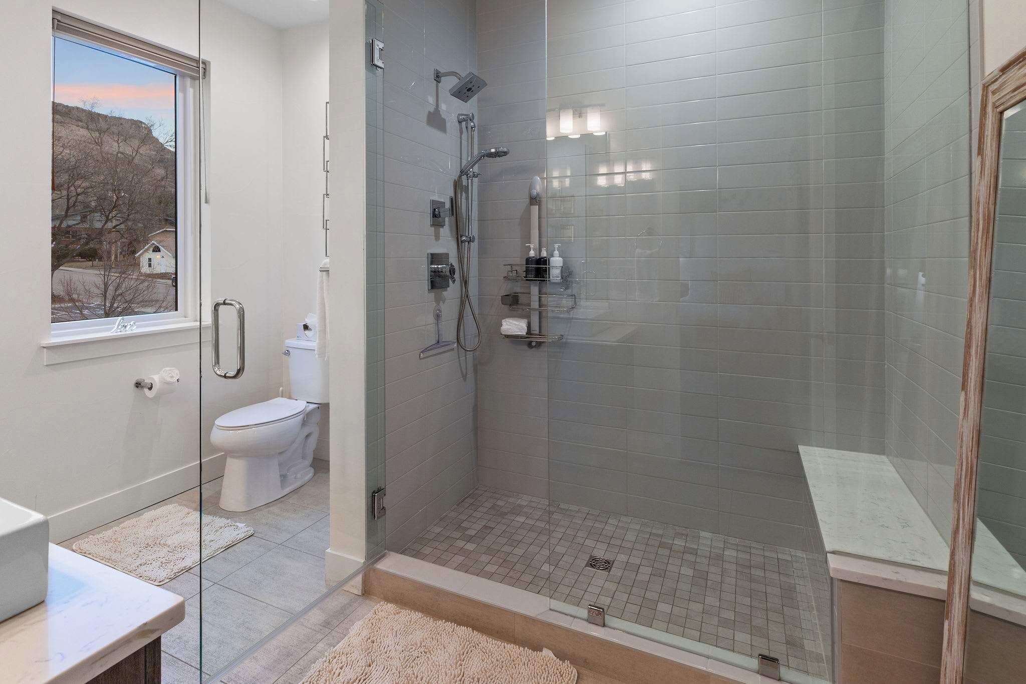 Un baño moderno con ducha de vidrio, inodoro y lavamanos.