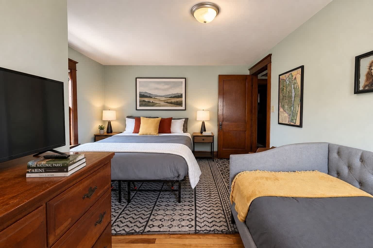 A hotel room with a bed, a sofa, a TV, and a desk.