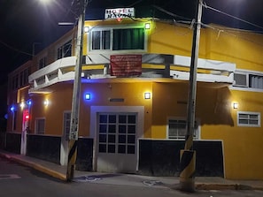 A hotel with a yellow facade, a signboard, and a visible entrance. - Hotel Nayar (Compostela)