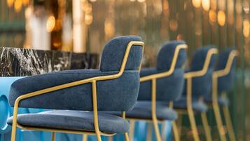 Rows of blue chairs with gold frames, arranged in a row.