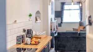 Une cuisine moderne avec un plan de travail en bois, une machine à café et une petite plante en pot.