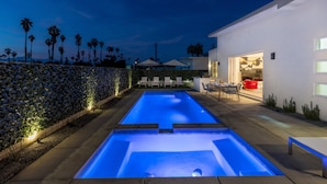 A swimming pool with a view of a modern house and palm trees. - Picture Perfect Retreat – Modern Hollywood Glam (Palm Springs)