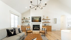 A modern living room with a fireplace, a sofa, two armchairs, and a coffee table. - New Heber home near Park City. 7brm/5.5ba with hot tub, pickleball, sleeps 18. (Heber City)