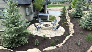 A patio area with stone flooring, a fire pit, and outdoor seating. - New Heber home near Park City. 7brm/5.5ba with hot tub, pickleball, sleeps 18. (Heber City)