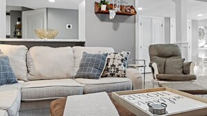 A modern living room with a sofa, a coffee table, and a decorative shelf with a vase and a bicycle. - Relaxing Retreat  (Westminster)