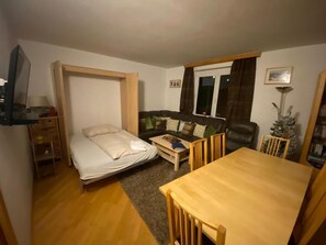 Relax and dine in this compact living space with a foldable bed, sofa, and dining table.