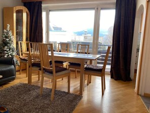 Cozy living area with a dining table for four, city views, and a Christmas tree.
