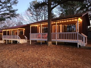 Step into this charming cabin, featuring a cozy porch with a staircase leading to the upper level.