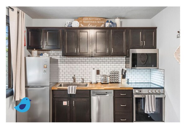 Enjoy cooking in this well-equipped kitchen with a spacious countertop, island, and ample storage.